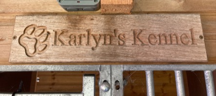 engraved wooden plaque on a kennel